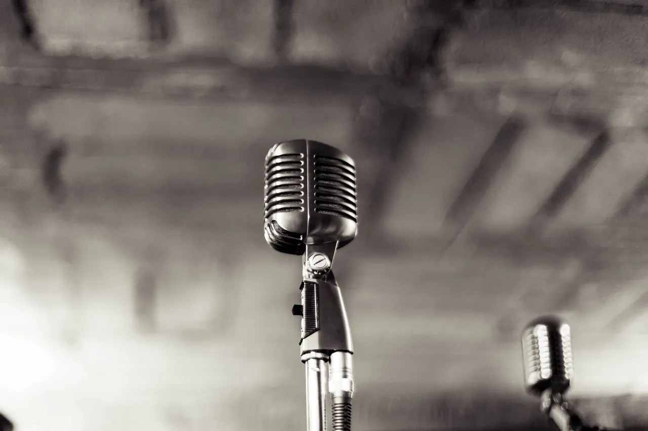 rs=w_1280 (3) A microphone is on the stand in front of a wall.